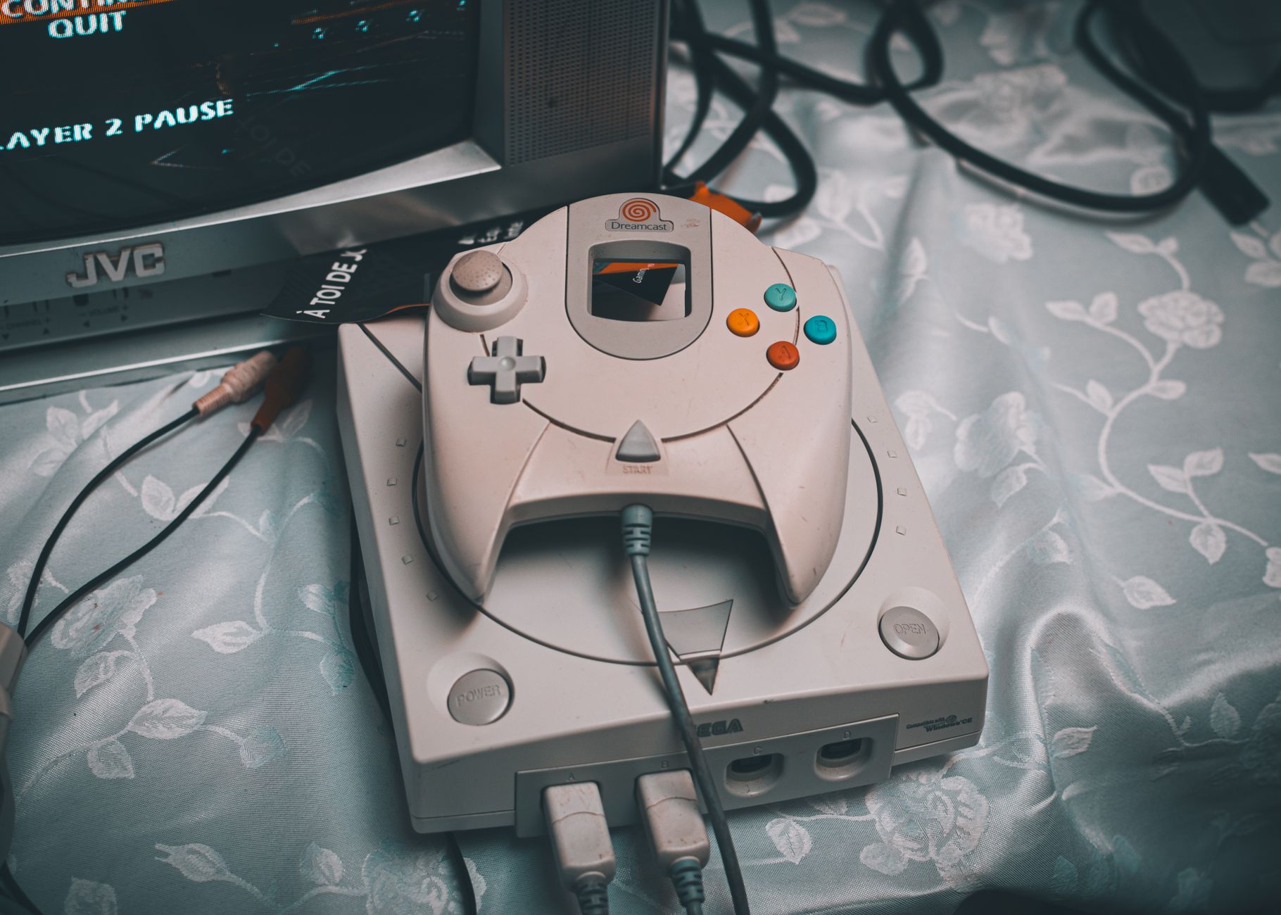 Konsola Sega Dreamcast z kontrolerem obok kineskopowego monitora retro