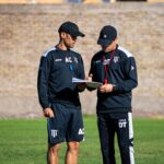 Najlepsze formacje i ustawienia w eFootball oraz EA FC, które poprawią twoją skuteczność w ataku i obronie Dwaj trenerzy piłkarscy omawiają taktykę na boisku w słoneczny dzień