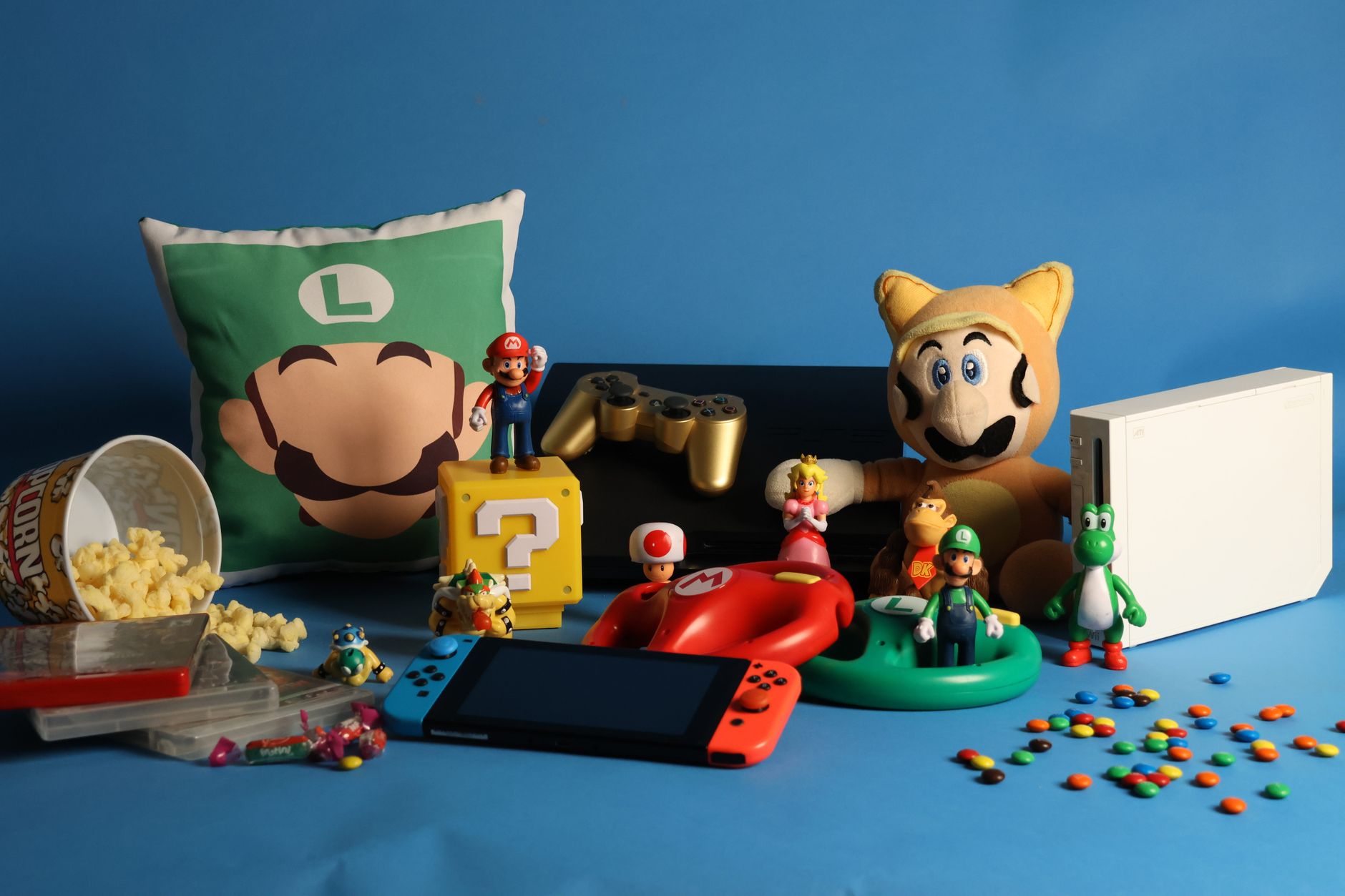 Kolekcja figurek Nintendo, konsol i słodyczy na niebieskim tle