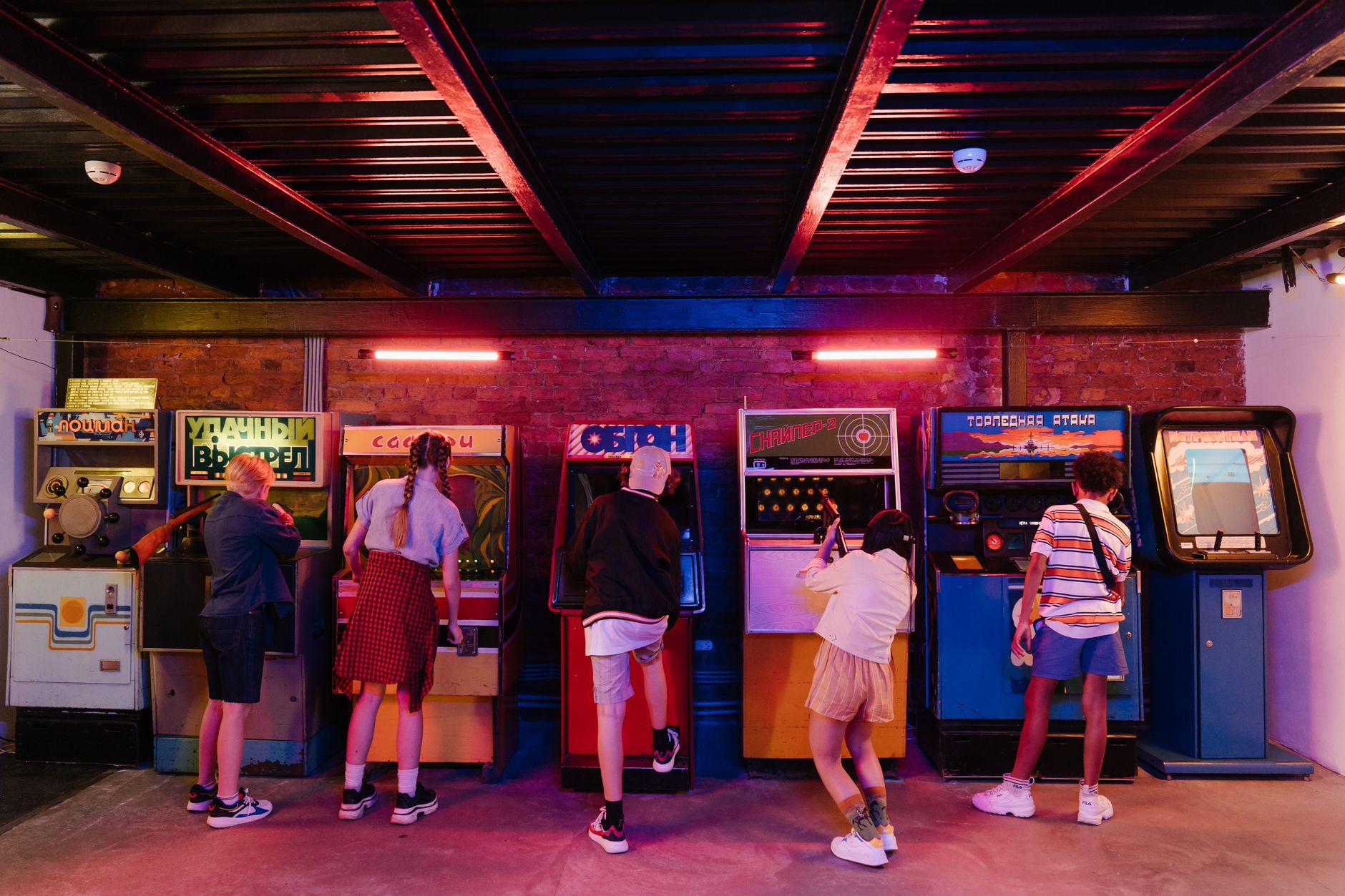 Nastolatki grające wspólnie na retro automatach arcade