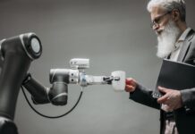Starszy mężczyzna odbiera kubek od ramienia robota w nowoczesnym biurze