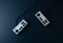 Dwa retro kontrolery do gier na ciemnym minimalistycznym tle