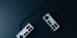 Duke Nukem 3D po latach: czy król strzelanek wciąż rządzi? Dwa retro kontrolery do gier na ciemnym minimalistycznym tle