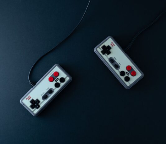 Dwa retro kontrolery do gier na ciemnym minimalistycznym tle