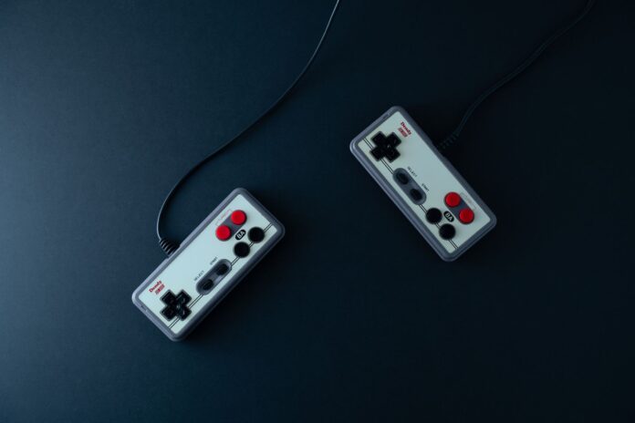 Dwa retro kontrolery do gier na ciemnym minimalistycznym tle