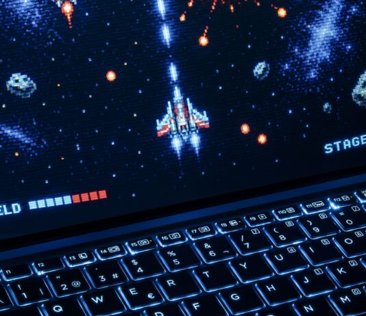 Laptop z retro kosmiczną strzelanką, podświetlana klawiatura